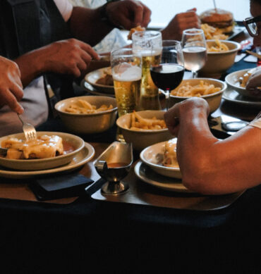 Groupe de clients dégustant une Francesinha avec frites et boissons chez Dona Maria à Neuchâtel
