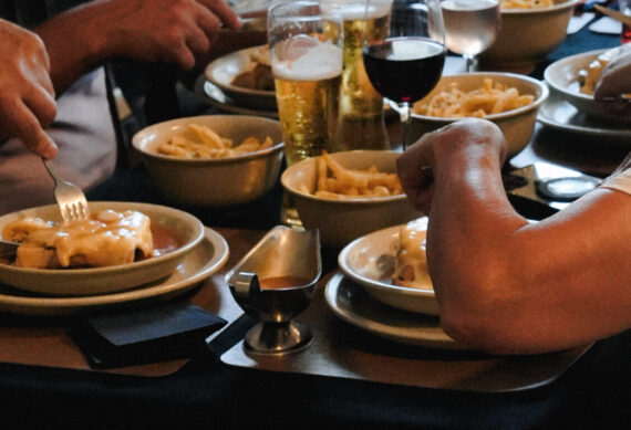 Groupe de clients dégustant une Francesinha avec frites et boissons chez Dona Maria à Neuchâtel